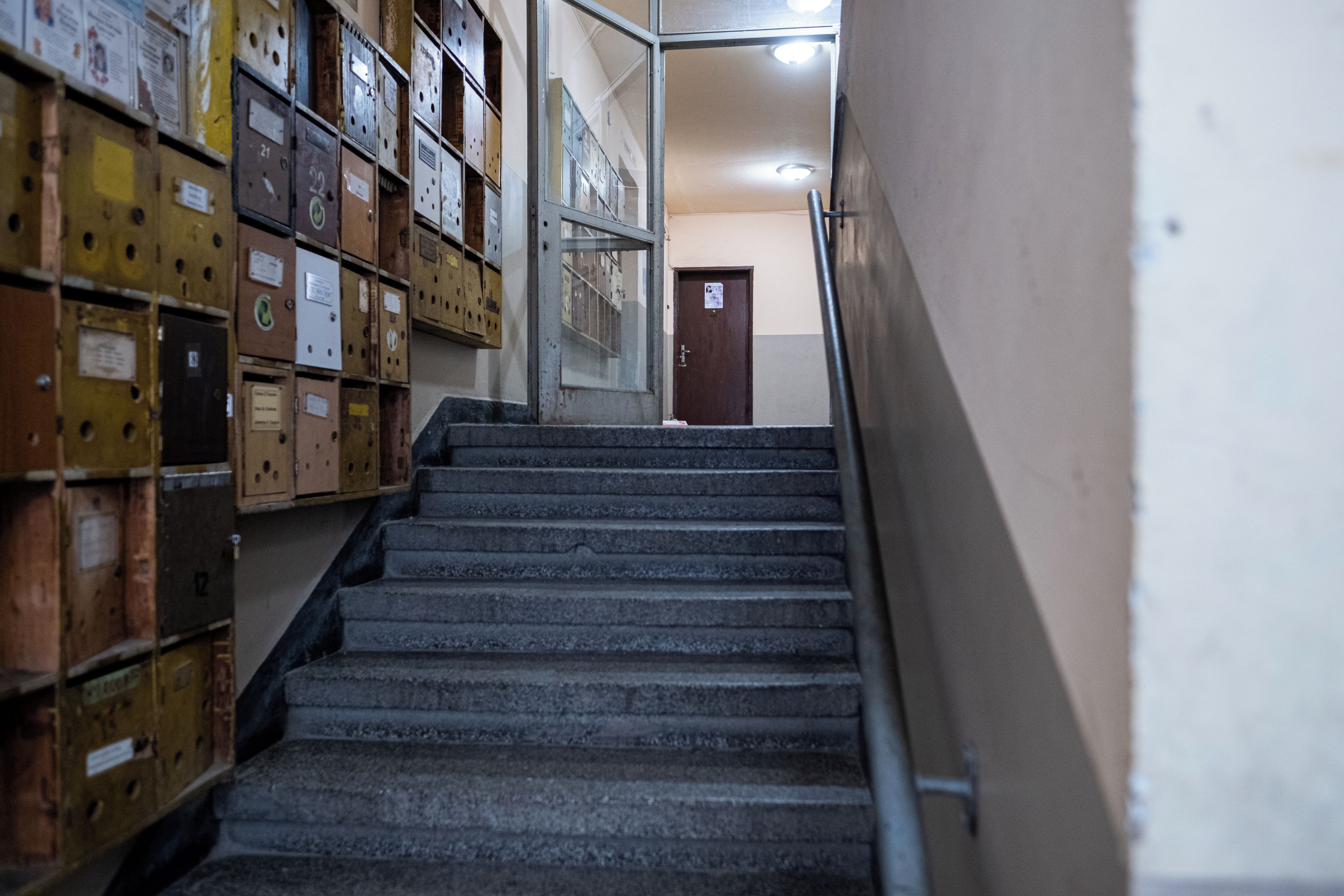 A staircase leading to a door with filing cabinets on either side.