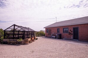 A building with a brick facade and a covered structure with wooden beams. - Langa Elihle on Paradise Beach (Jeffreys Bay)