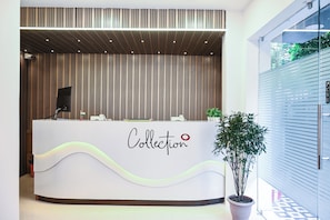 A reception desk with a modern design, featuring a logo that reads 'Collection' and a red dot symbol. - Collection O Heritage Near Acropolis (Kolkata)