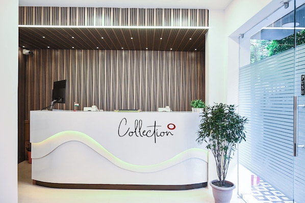 A reception desk with a modern design, featuring a logo that reads 'Collection' and a red dot symbol. - Collection O Heritage Near Acropolis (Kolkata)