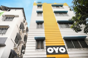 A building with a prominent yellow stripe and the logo 'OYO' on the facade. - Collection O Heritage Near Acropolis (Kolkata)