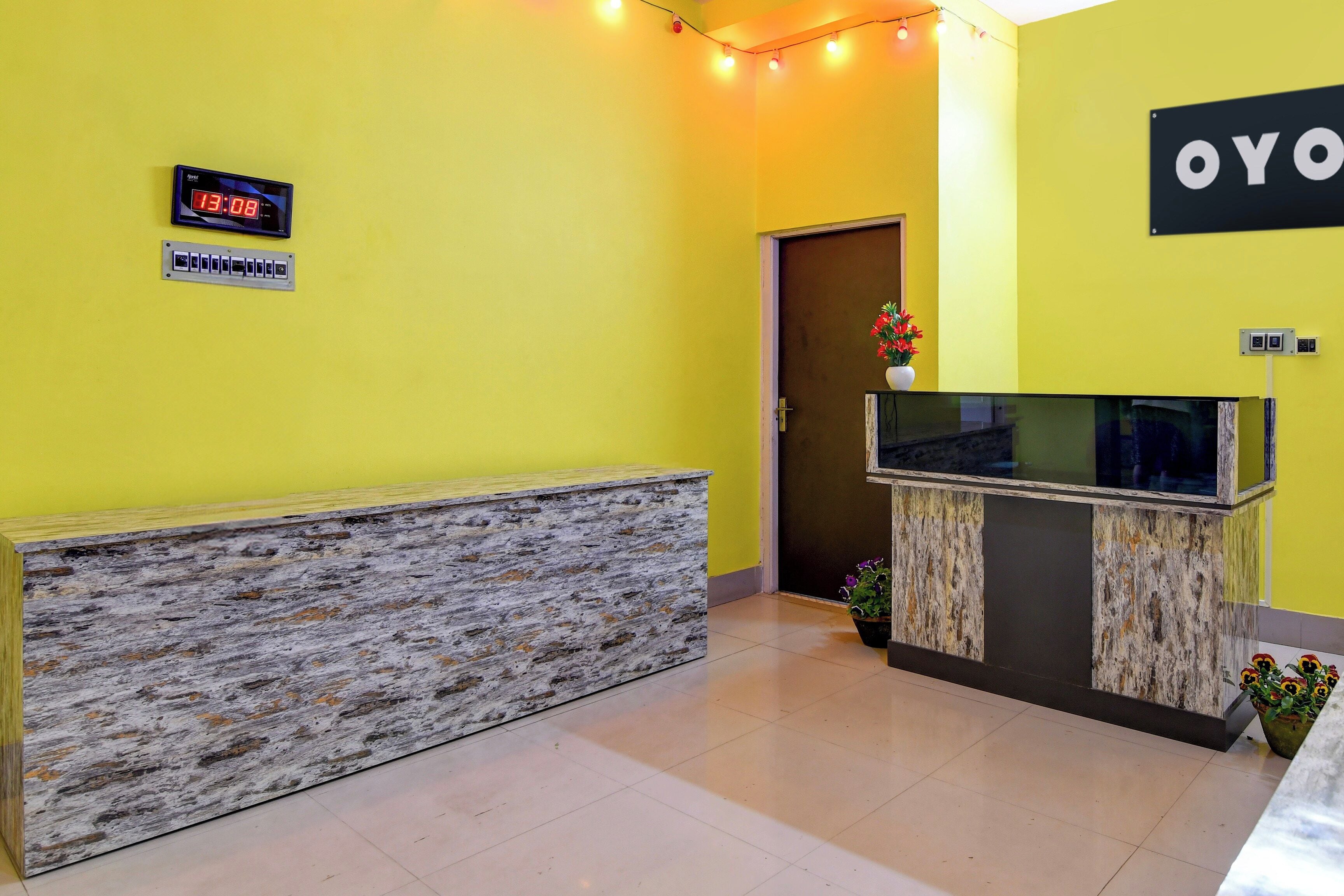Zona de recepción con mostrador de piedra, reloj digital y un letrero que dice 'YOYO'.