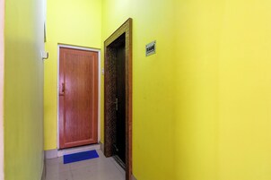 Un pasillo con una puerta de madera y un enchufe en la pared.