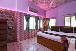 Un dormitorio con cama, ventilador de techo y ventana con cortinas.
