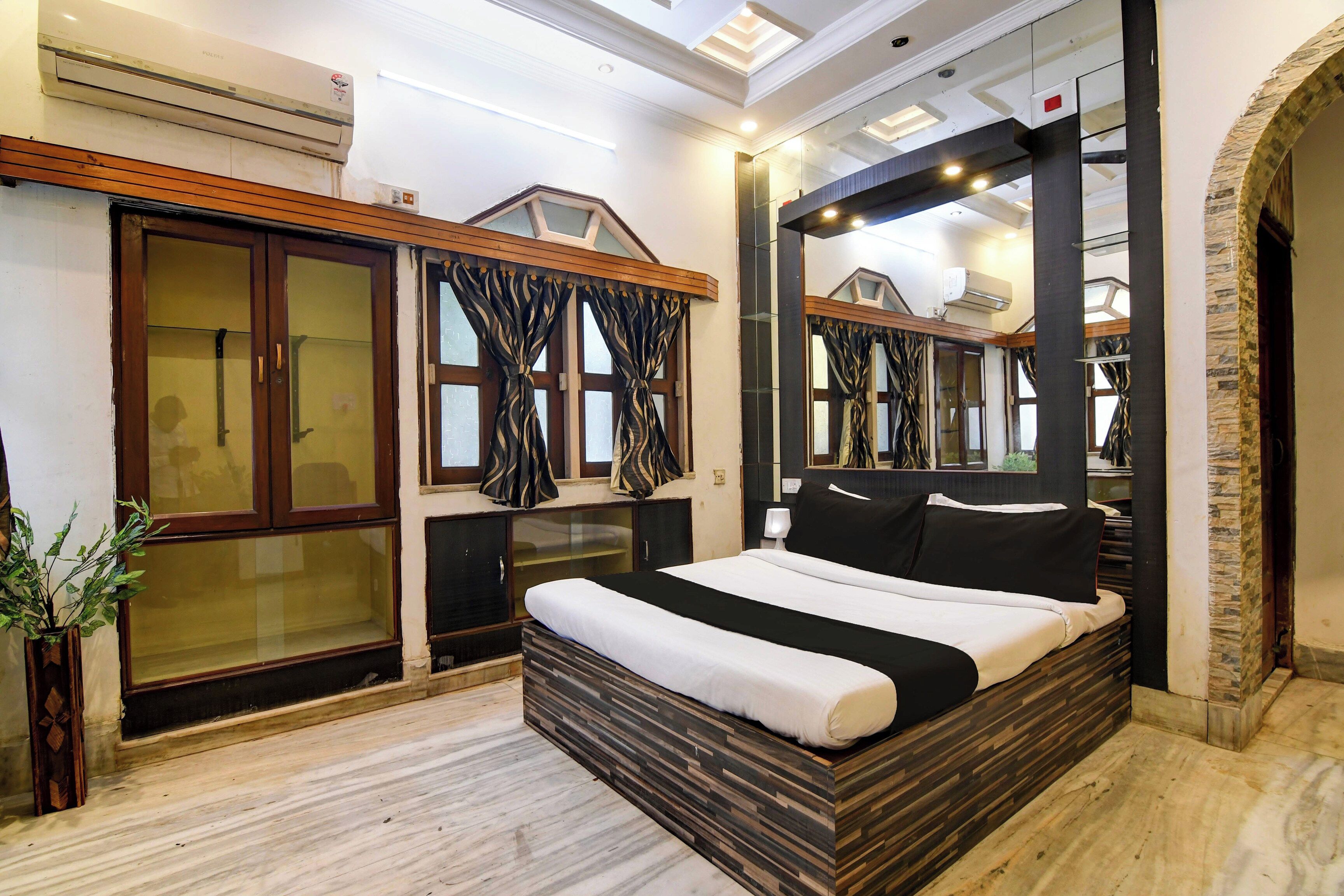 Un dormitorio moderno con una cama grande, armario y espejo.