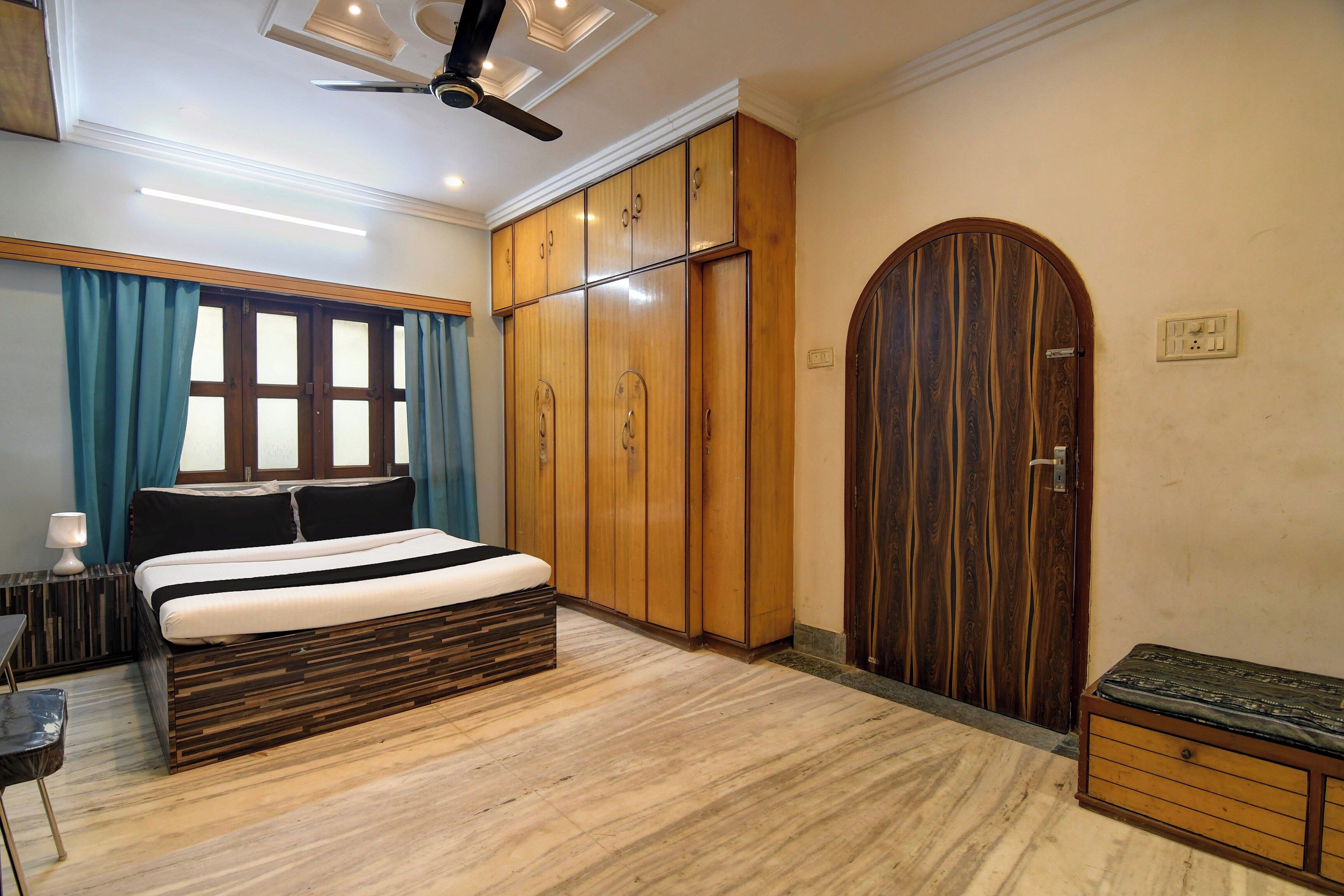 Un dormitorio con cama, armario y una puerta grande de arco.