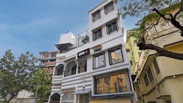 Un edificio de varios pisos con balcones, un cartel que dice 'Avenue Villa' y un depósito de agua en el techo.