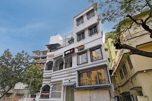 Un edificio de varios pisos con balcones, un cartel que dice 'Avenue Villa' y un depósito de agua en el techo.