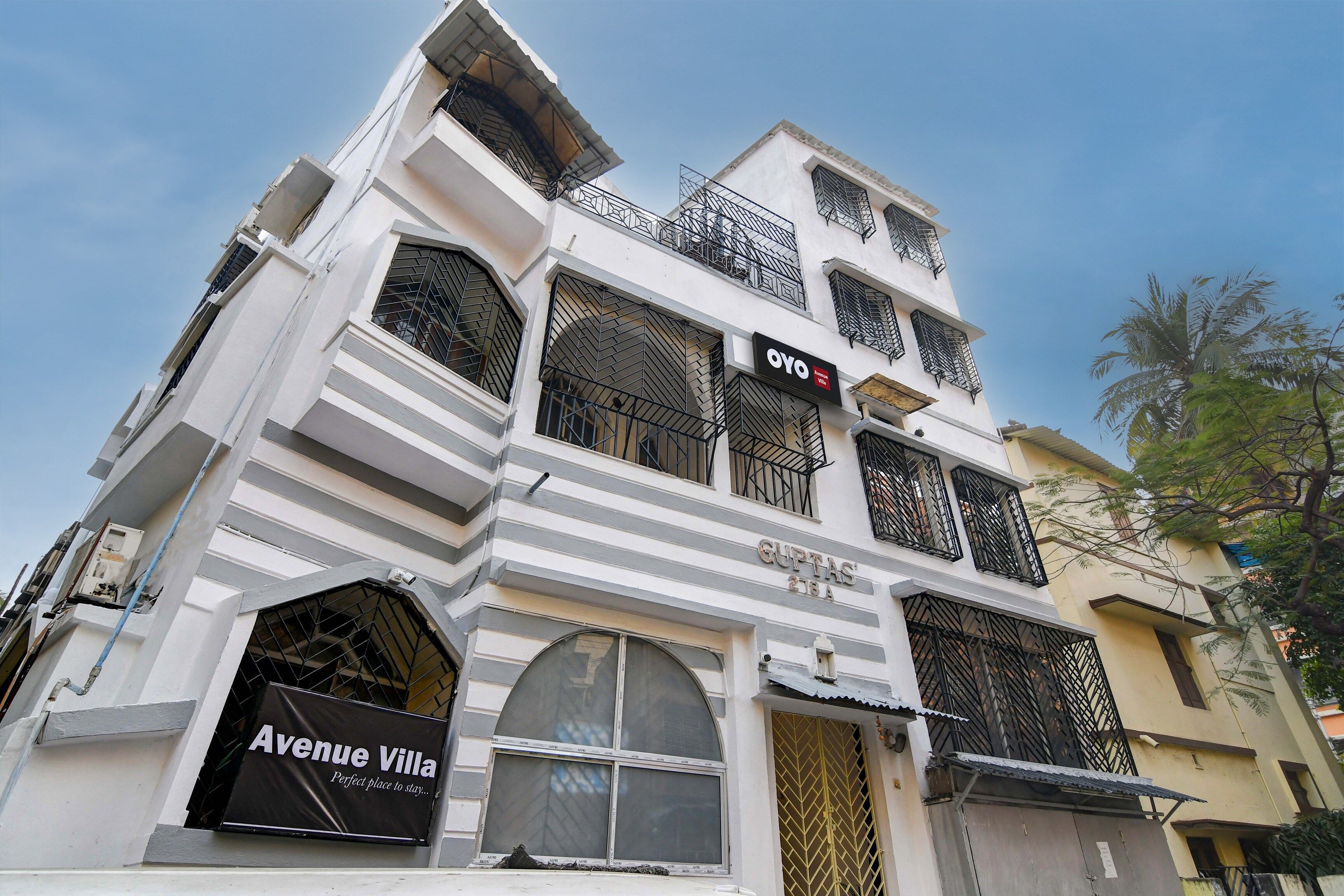 A multi-story building with balconies and a sign for 'Avenue Villa.'