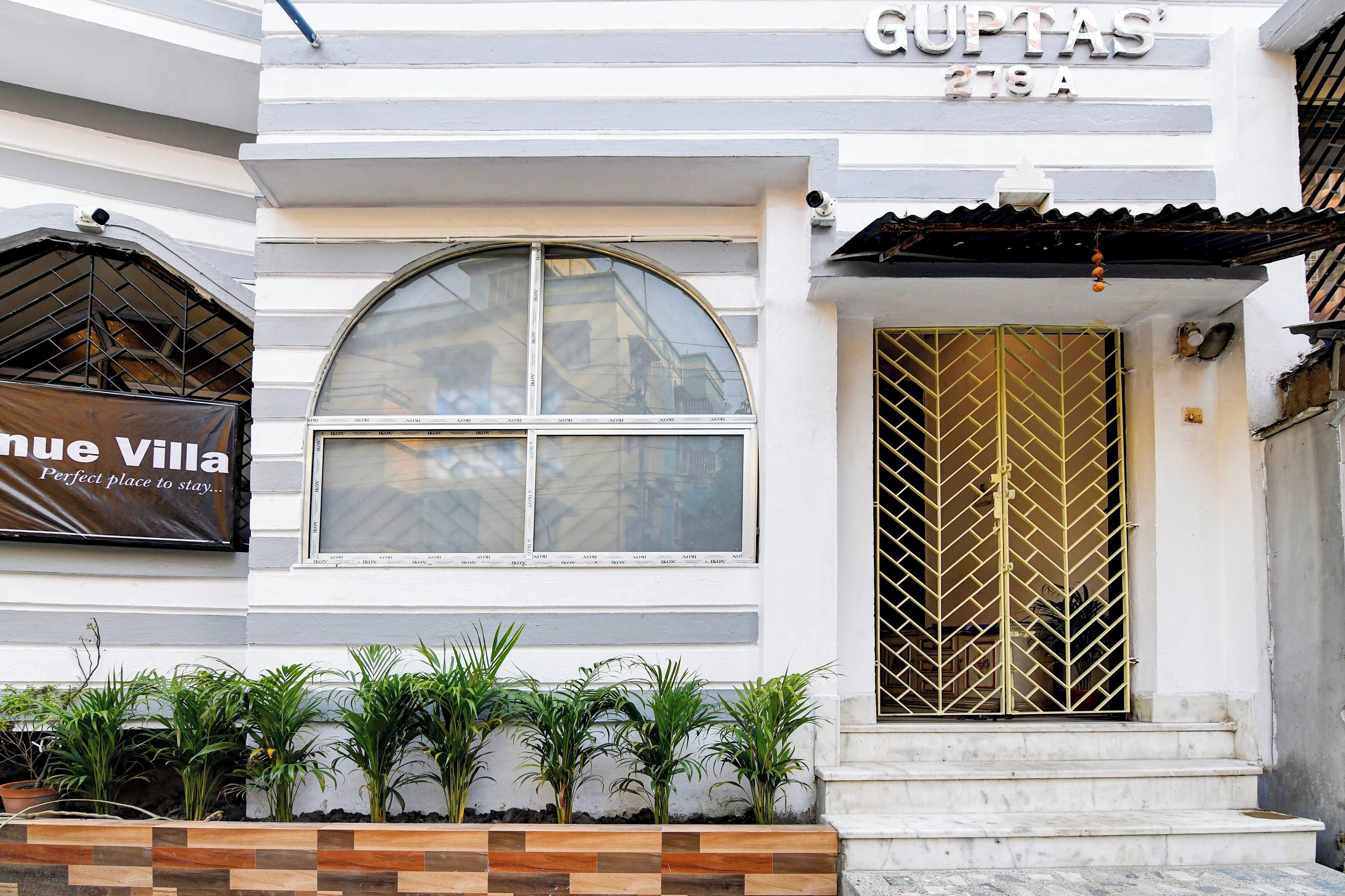 Un edificio con un letrero que dice 'GUPTAS 278A' y un cartel de 'Nou Villa' que anuncia 'Lugar perfecto para hospedarse'.