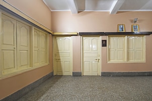 Un pasillo con puertas color crema, un marco negro en la pared y una pequeña placa.