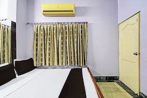 Habitación de hotel con cama, armario, aire acondicionado y cortina estampada.