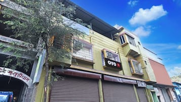 Un bâtiment avec une enseigne indiquant « OYO » et une autre enseigne, partiellement visible, dont le texte est écrit dans un alphabet non latin.