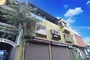 A building with a sign for 'OYO' and a partially visible sign with text in a non-Latin script. - Hotel O Arati House (Howrah)