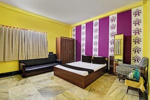 Een slaapkamer met een bed, een bank, een kledingkast en een stoel.