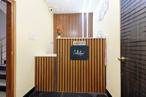 En receptionsdisk med en skylt som visar ”RECEPTION”, en krukväxt och en skylt som visar ”INLÄMNING”.