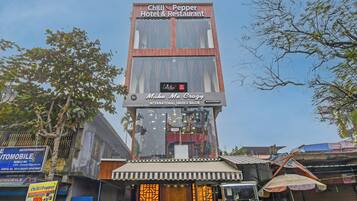 Un bâtiment sur lequel on peut lire les enseignes « Chilli Pepper Hotel & Restaurant » et « Make Me Crazy International Unisex Salon ».