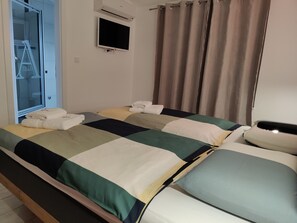 A hotel room with two beds, a TV, and a window with curtains. - Villa A GRAND Poolside Apartment  heating pool (Okrug Gornji)