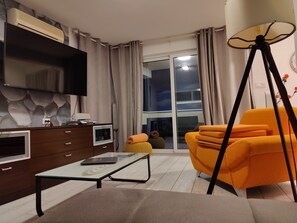 A modern living room with a flat-screen TV, a sofa, a coffee table, and a lamp. - Villa A GRAND Poolside Apartment  heating pool (Okrug Gornji)