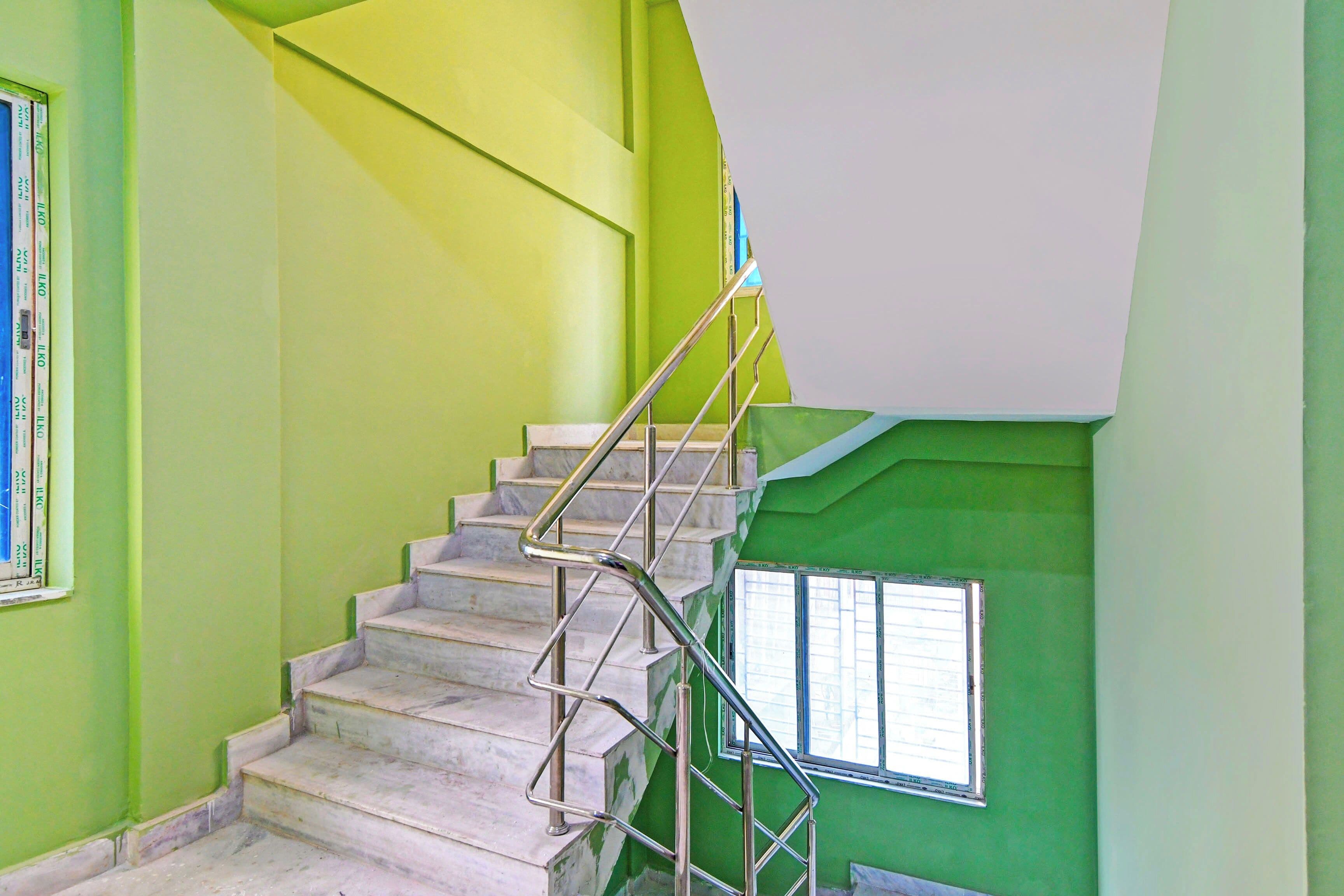 A staircase with metal railings leading to a landing with a window.