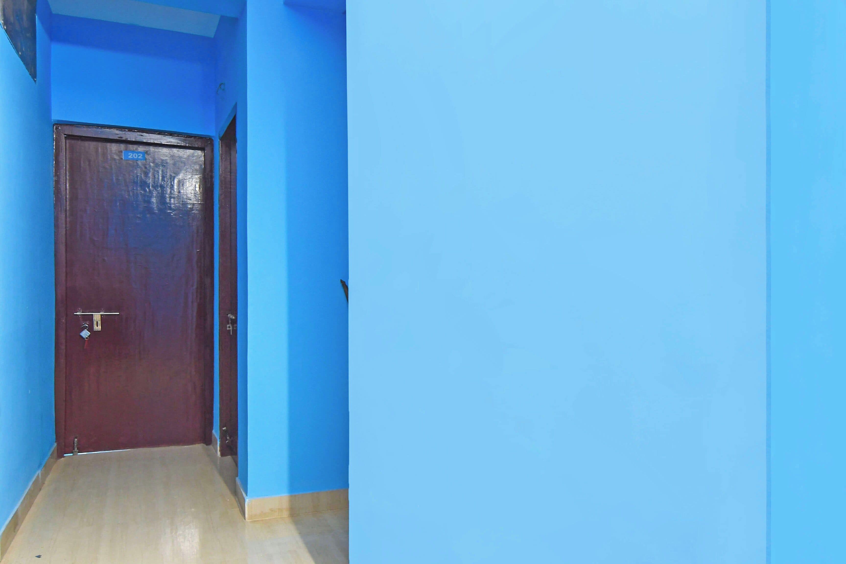 A hallway with a wooden door and blue walls.