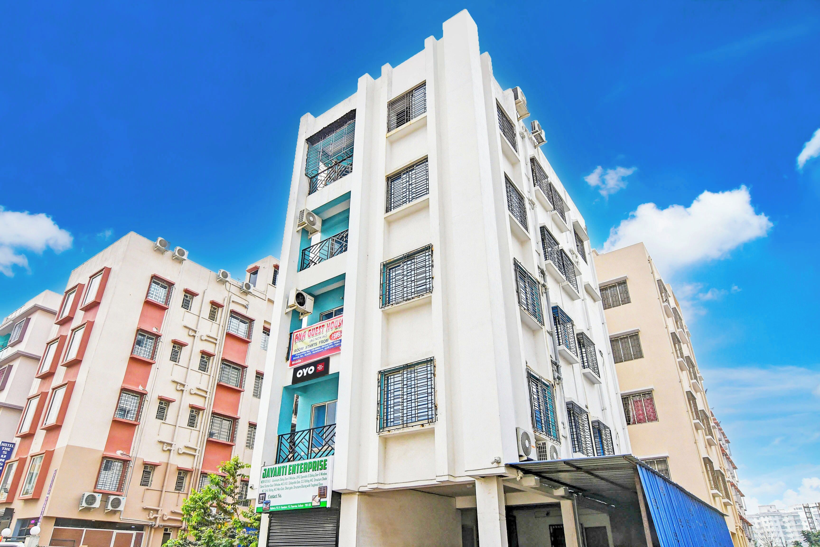 A multi-story building with a sign for 'ANA GUEST HOUSE' indicating room availability.