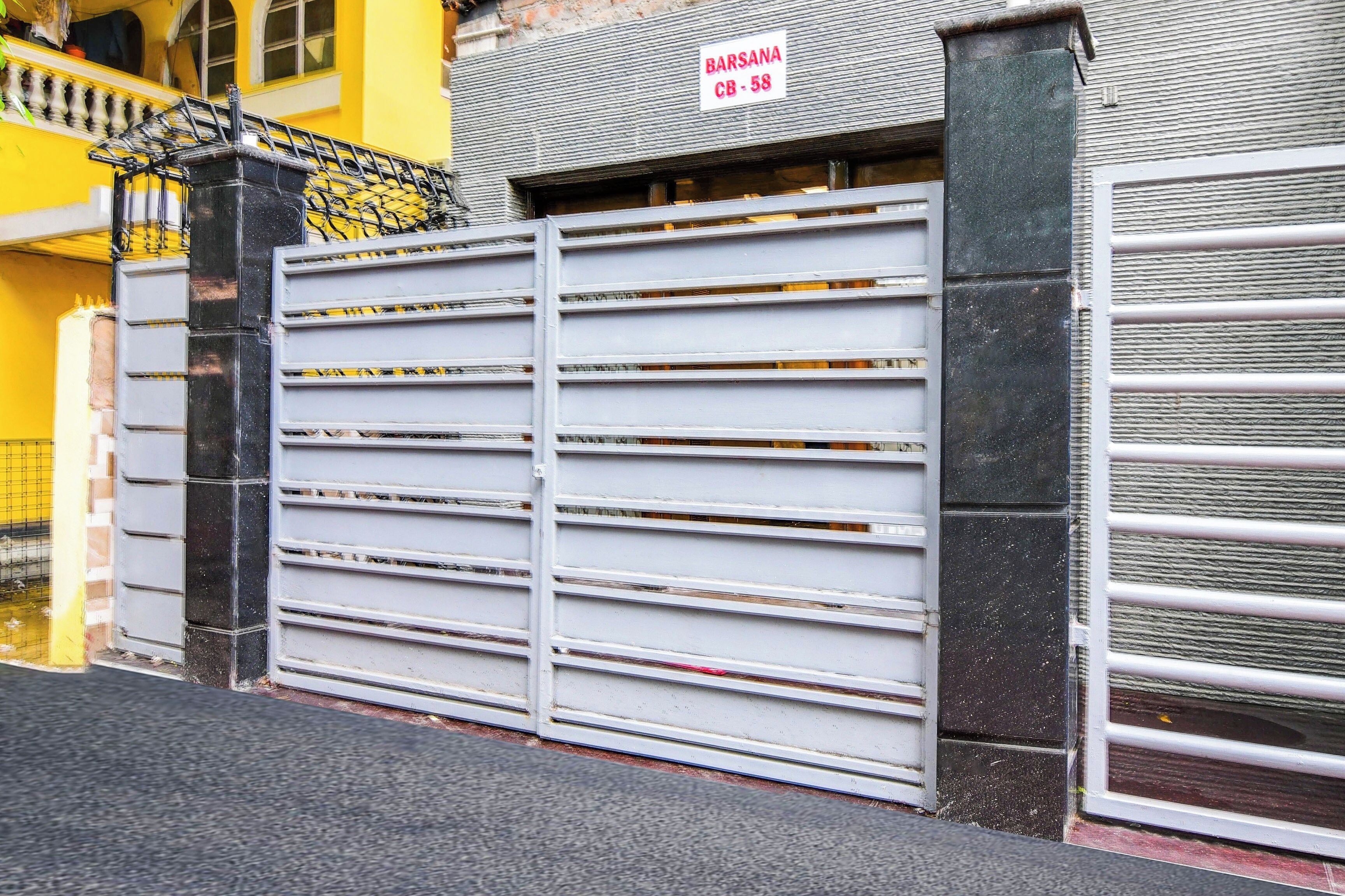 A gated entrance with a metal gate and a sign above it.