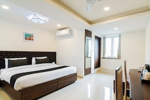 A hotel room with a large bed, a bedside table, a window, and an air conditioning unit. - Hotel O Eminent Hotel (Kolkata)