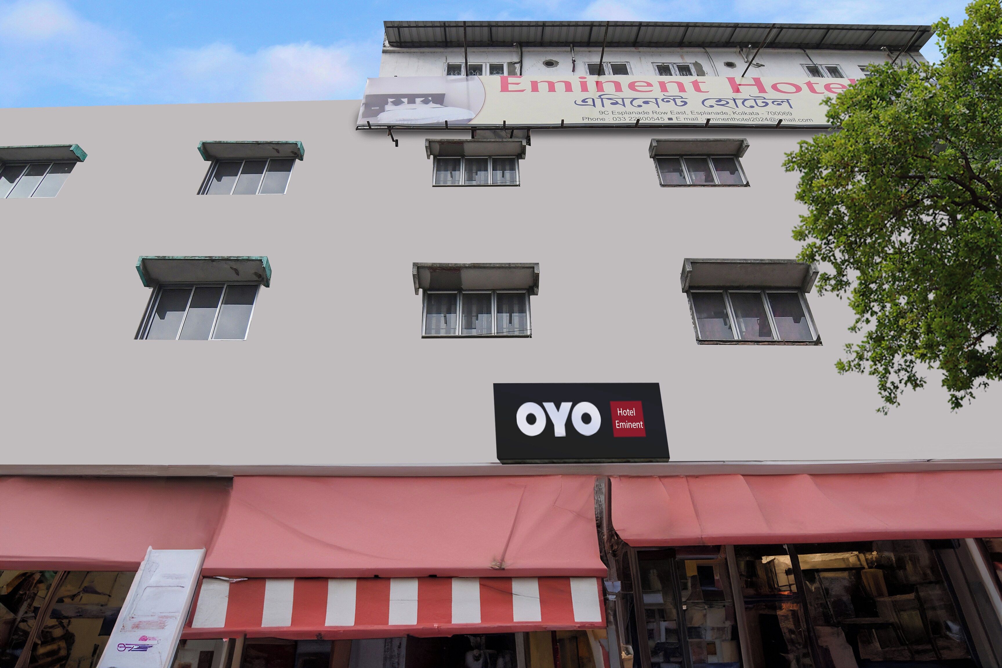 Un bâtiment d’hôtel doté de nombreuses fenêtres et d’une enseigne indiquant « Eminent Hotel ».