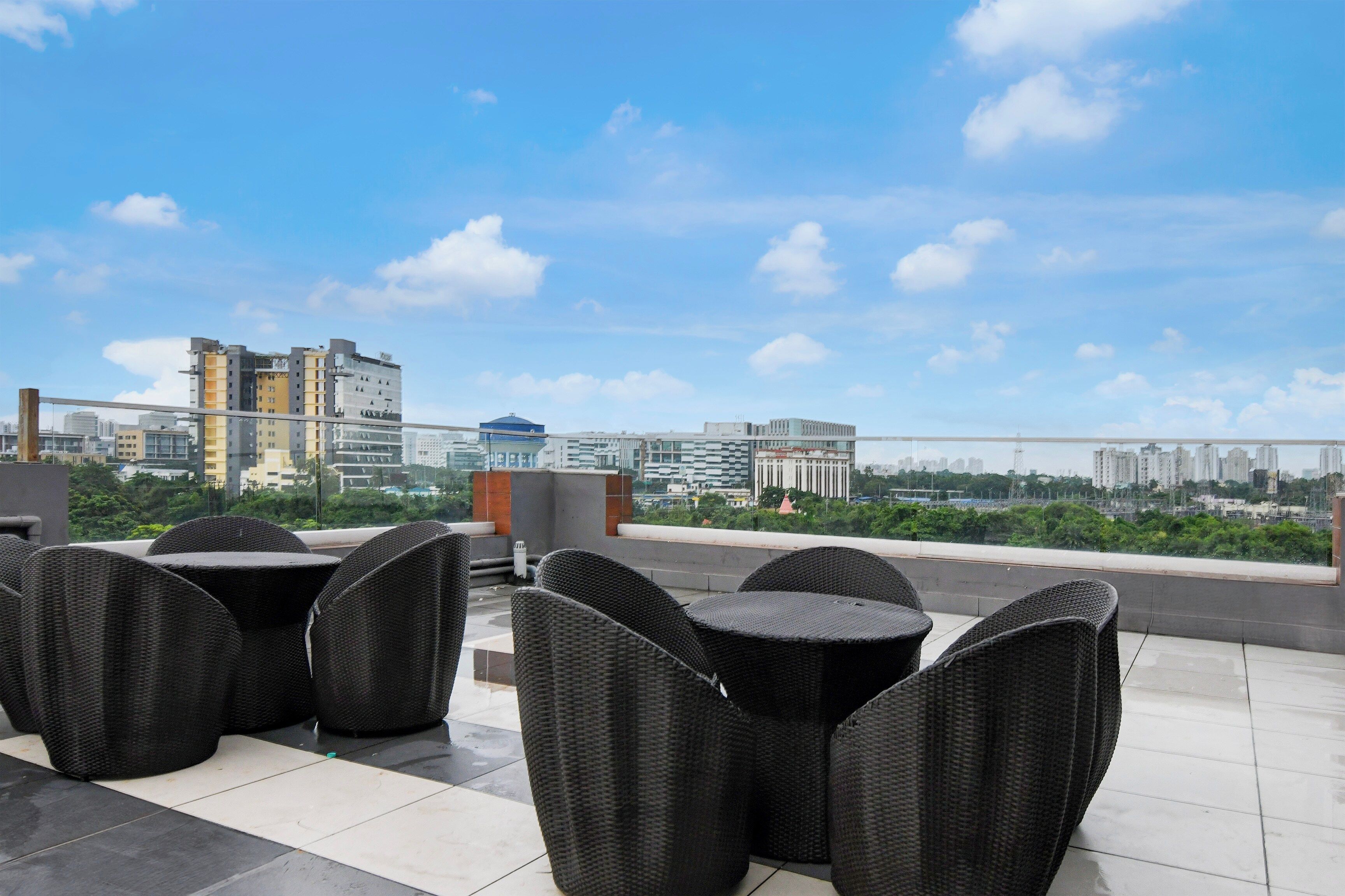 Una terraza en la azotea con mobiliario exterior y vistas a la ciudad.