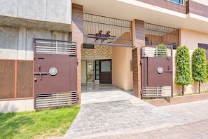 A gated entrance with a modern design, a staircase leading to a covered area, and a well-maintained lawn. - Hotel O PREM VILLA HOME STAY (Amritsar)