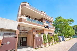 A modern two-story hotel with a flat roof, large windows, and a sign indicating it is a hotel. - Hotel O PREM VILLA HOME STAY (Amritsar)
