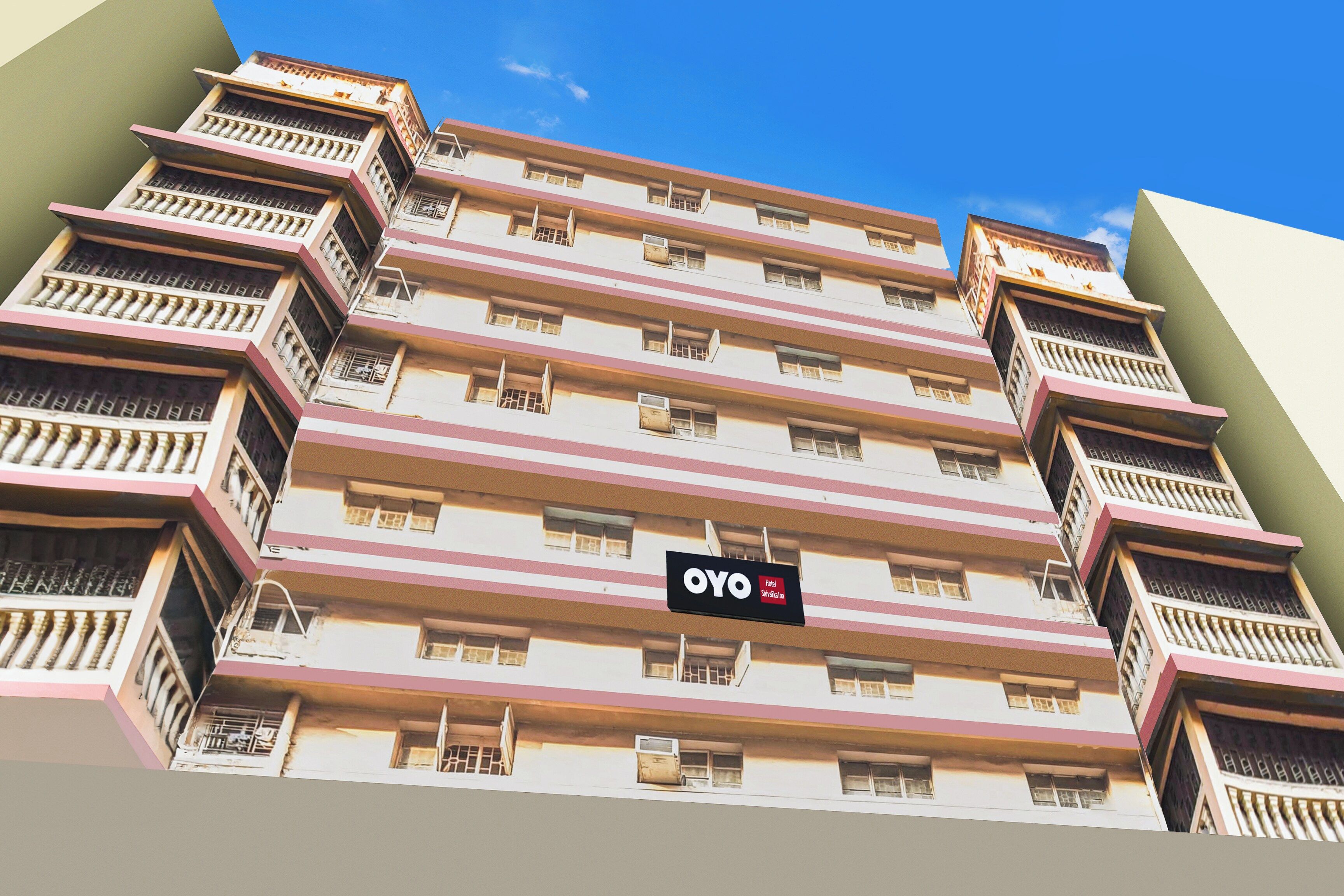 Un immeuble hôtelier à plusieurs étages, doté de balcons, avec une enseigne indiquant qu’il s’agit de l’hôtel OYO Shikla Im.
