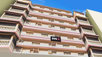 Un immeuble hôtelier à plusieurs étages, doté de balcons, avec une enseigne indiquant qu’il s’agit de l’hôtel OYO Shikla Im.