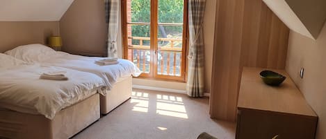 Une chambre à coucher avec un lit, une petite table et une vue sur l’extérieur par une fenêtre.