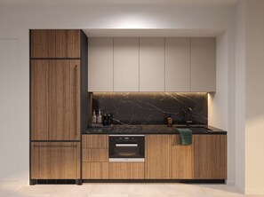 Una cocina moderna con armarios de madera, salpicadero de mármol y electrodomésticos integrados.