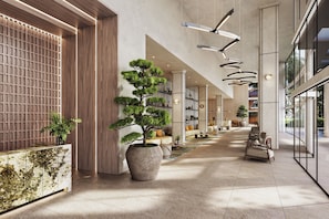 Een modern interieur met een lange gang, grote kamerplanten en eigentijds meubilair.