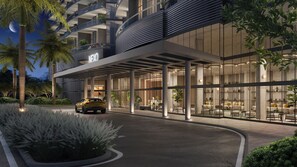 A modern hotel entrance with a car parked in front, a covered outdoor seating area, and a building with a 'NEYO' sign. - High Floor Signature Suite | Brand New | Resort Pool + Gym | Nexo Miami (North Miami Beach)