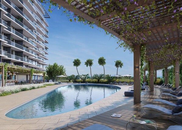 Una piscina con terraza de madera, sillas de descanso y una zona cubierta con plantas.
