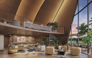 A spacious lounge area with multiple seating options, a high ceiling with wooden panels, and large windows offering a view of palm trees. - Premier Studio | Brand New | Resort Pool + Gym | Near Beach | Nexo Miami (North Miami Beach)