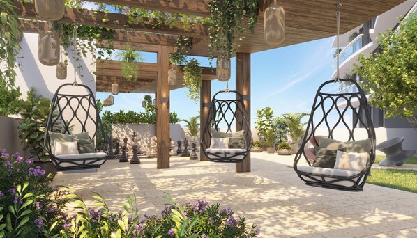 Un espace extérieur aménagé, abrité et doté de chaises suspendues et de jardinières.