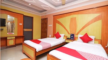 Habitación de hotel con dos camas, un escritorio, un espejo y un ventilador de techo.