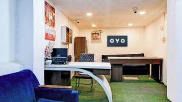 Een kamer met een bureau, computer, stoel en een bordje met de tekst 'OYO'.