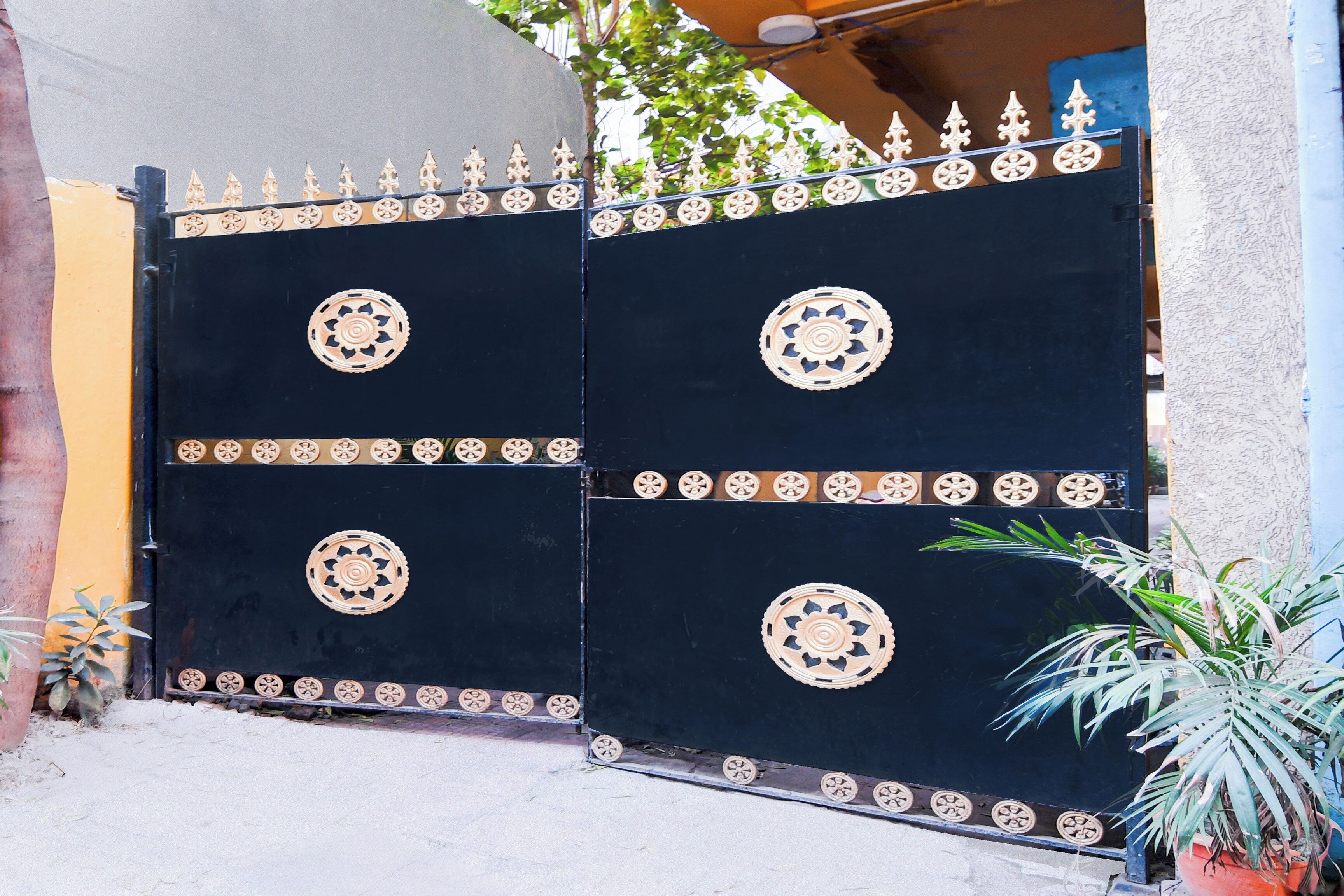 A black gate with ornate circular designs and a decorative top rail.