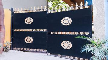 A black gate with ornate circular designs and a decorative top rail.