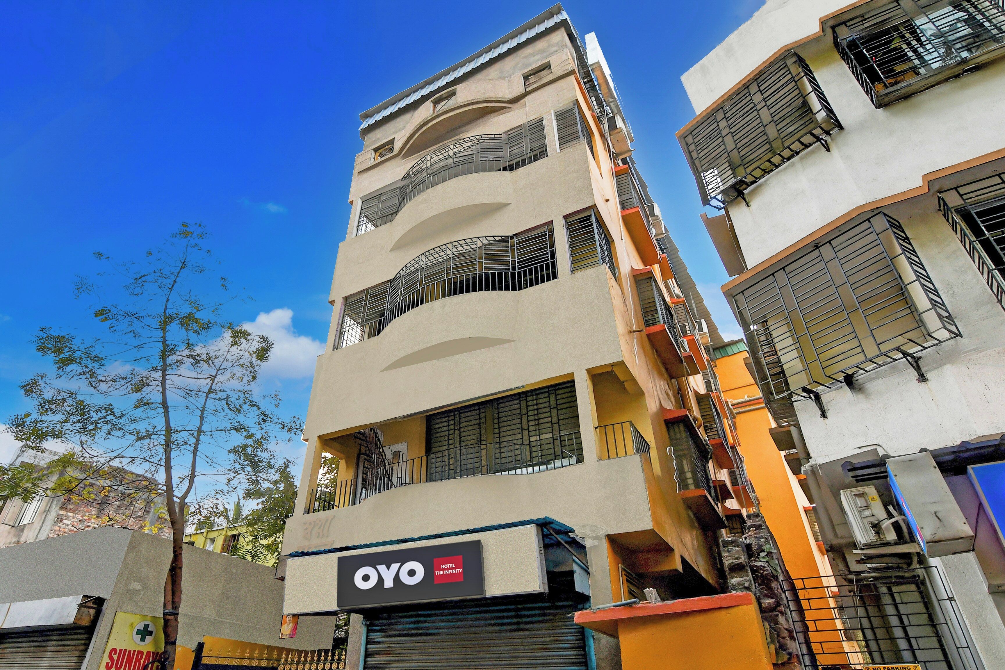 A multi-story building with a sign for 'OYO Hotel The Infinity' indicating a hotel presence.