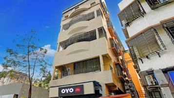 A multi-story building with a sign for 'OYO Hotel The Infinity' indicating a hotel presence.