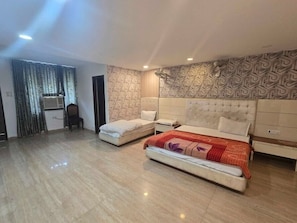 A hotel room with a large bed, a bedside table, a wardrobe, and a patterned wall. - Hotel O Golden Gate (Amritsar)