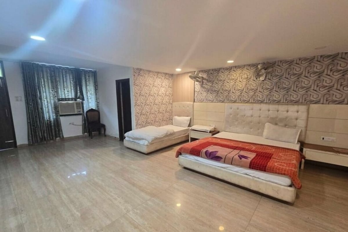 Un dormitorio con dos camas, un papel tapiz estampado y piso de baldosas.