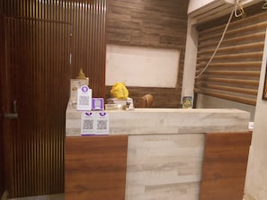 Ein Empfangsbereich mit Holzausschnitt, einem Check-in-Schalter und einer Wand-Klimaanlage.
